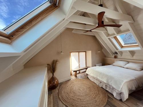 une chambre avec un lit et un ventilateur de plafond dans l'établissement Grange Aguila - Chalet au pied des pistes, à Vignec
