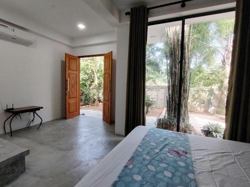a bedroom with a bed and a large glass door at Sea Path Villa - Dikwella in Dickwella