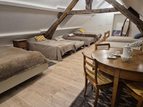 Zimmer mit 4 Betten, Tisch und Stühlen in der Unterkunft La Parenthese 