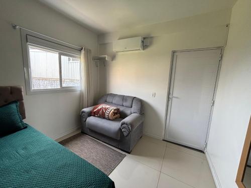 ein kleines Zimmer mit einem Sofa und einem Fenster in der Unterkunft Kitnet Suíte Premium in Bento Gonçalves
