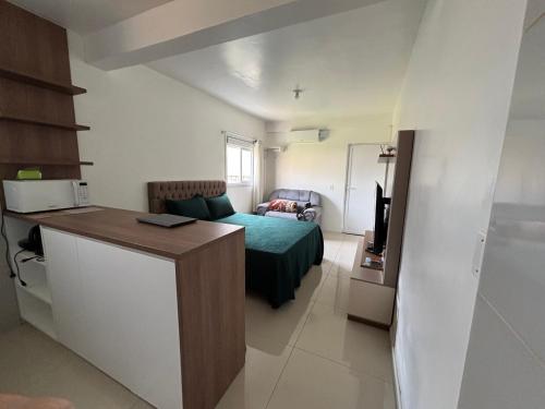 Zimmer mit einem Bett und einer Küche mit einem Schreibtisch in der Unterkunft Kitnet Suíte Premium in Bento Gonçalves