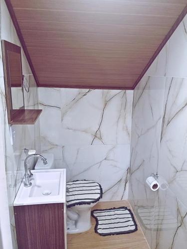 a bathroom with a sink and a toilet at Ares da Bocaina Suítes in Bananal
