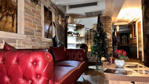 a living room with a red couch and a christmas tree at Hotel SPHENDON in Istanbul