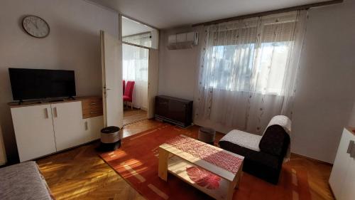 a living room with a couch and a table and a tv at Stan Na Dan Ćuprija in Ćuprija