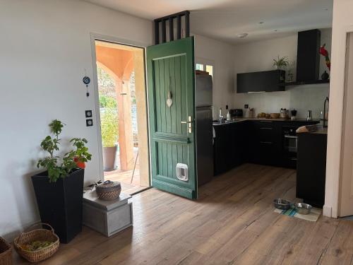 a kitchen with a green door in a room at vue sur le golfe de Saint Florent in Saint-Florent