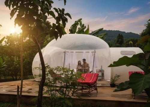 two people standing in a dome tent on a deck at Safari Bubbles in Wundanyi