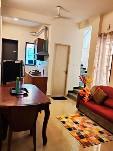 ein Wohnzimmer mit Sofa und Tisch in der Unterkunft Olive Villa ECR - Private 2 BHK villa in Tirupporūr