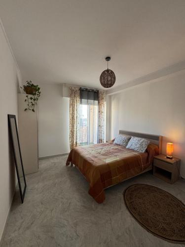 una camera da letto con un letto e una grande finestra di Cherry & Mountain Appartement ad Ajaccio