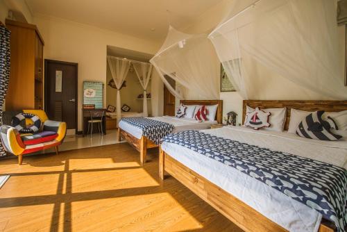 湖西鄉的住宿－Sabai B&B 澎湖船家寶民宿，一间卧室配有两张床和椅子