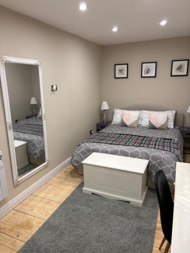 a bedroom with two beds and a mirror at Modern secure townhouse in Oldcastle