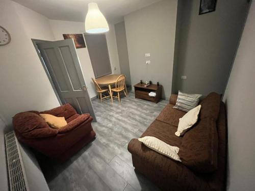 a room with a bed and a couch and a chair at Heath lodge in Newcastle under Lyme