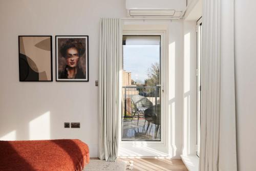 a bedroom with a door leading to a balcony at 2-Bed Apartments a Short Walk to Wembley Stadium in London