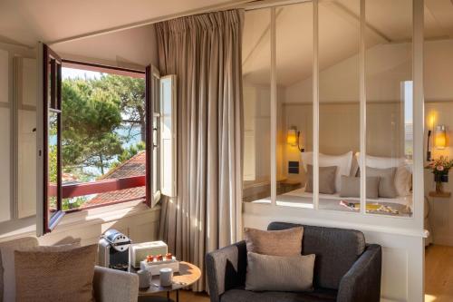 a living room with a couch and a bedroom at Villa du Pyla in Pyla-sur-Mer