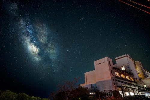 a starry night with a building and the milky way at Ashizuri Kokusai Hotel in Tosashimizu
