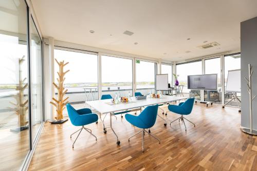 uma sala de conferências com cadeiras azuis e uma mesa em Hotel Soho em Landau in der Pfalz