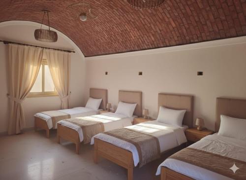 a room with three beds and a window at Crystala guest house in Aswan