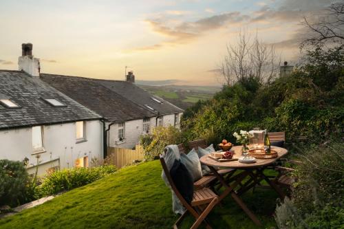 a table and chairs on top of a yard at 1 Rock Cottages in Treknow