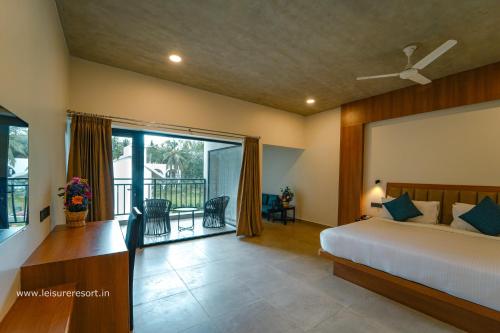 une chambre avec un lit et un balcon dans l'établissement Leisure Resort, à Pondichéry