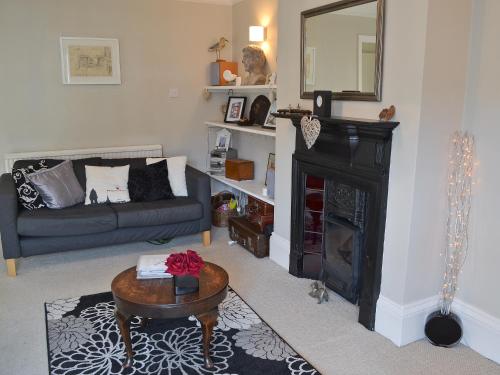 a living room with a couch and a fireplace at The Broomes in Whitstable