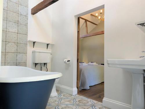 a bathroom with a bath tub and a sink at The Stables - Uk50804 in Cratfield