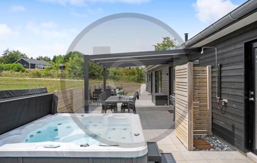 bañera de hidromasaje en el patio de una casa en 6 Bedroom Awesome Home In Glesborg, en Fjellerup Strand