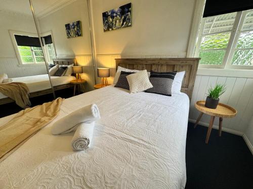 Cosy Cottage 4173 في بريزبين: غرفة نوم بسرير كبير مع ملاءات ووسائد بيضاء