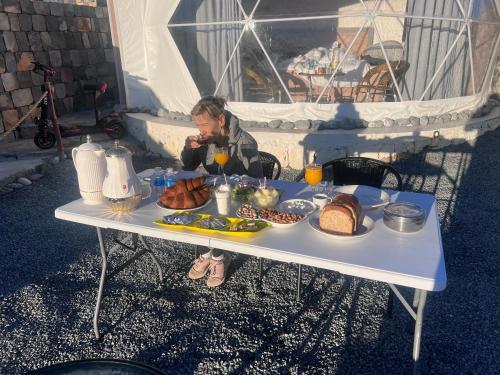 Een man aan een tafel met eten erop. bij قبة سماء جبل شمس - qubat sama jabal shams in Jebel Shams