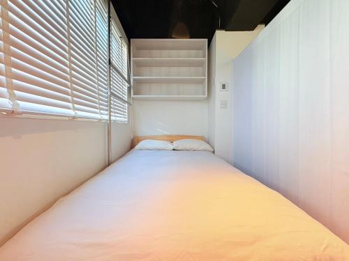 a small bedroom with a large bed in it at GARDEN HOUSE Tameike-Sanno in Tokyo