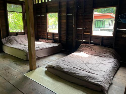 two beds in a room with two windows at Balance home happy in Ko Yao Noi