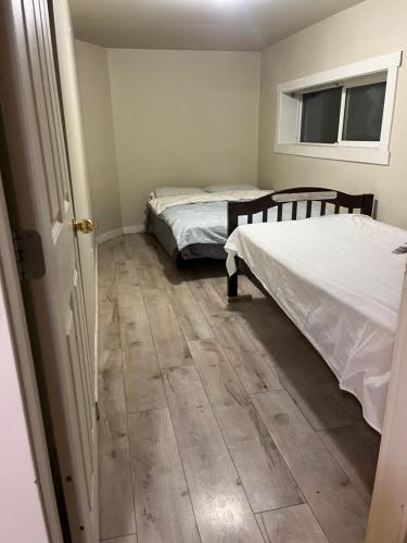 two beds in a room with wooden floors at Tillicum center 6 bedroom house in Oak Bay