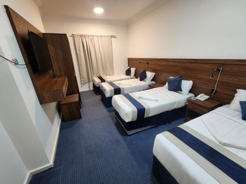 Una cama o camas en una habitación de اصول الجوهرة العزيزية توصيل مجاني الى الحرم Asoul Al Jawhara Al Azizia Free shuttle To Haram