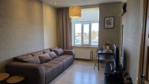 a living room with a couch and a television at Center apartment Great Amber in Liepāja