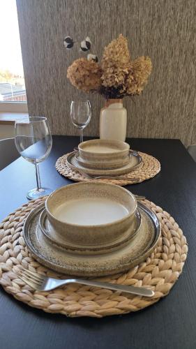 a table with plates and wine glasses on a table at Center apartment Great Amber in Liepāja