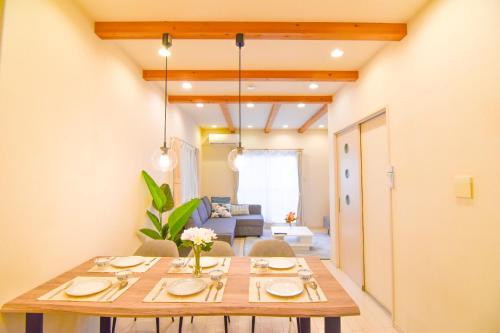 a dining room with a table and a couch at KAWAII House -Free Parking- in Osaka