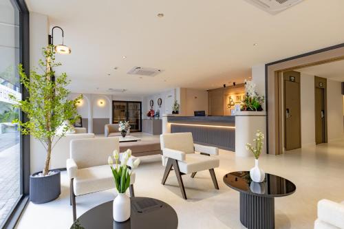 a living room with chairs and tables and a counter at The Bentley Hotel in Bangkok
