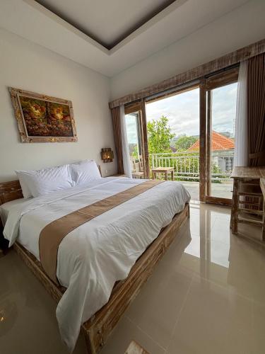 a bedroom with a large bed and a large window at Casa Benoa Homestay in Nusa Dua