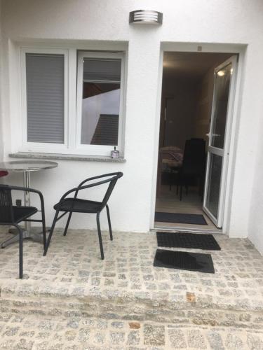 a patio with a chair and a table and a window at Pokoje przy strumyczku in Krobica