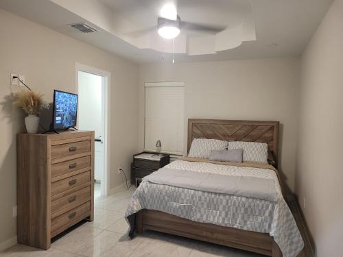 a bedroom with a bed and a dresser and a television at Serene Mission Oasis! in Mission