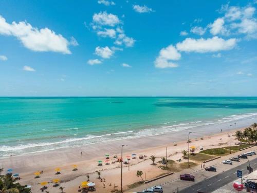 a view of a beach with umbrellas and the ocean at Flat 201 Paradise in João Pessoa