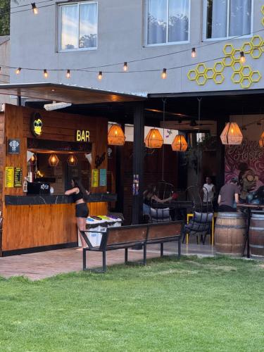 a woman is standing in front of a bar at Gorilla Hostel in Mendoza
