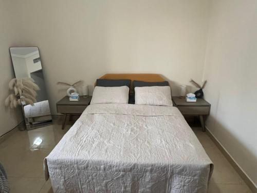 a bedroom with a bed with two tables and a mirror at comfort private master room in Sharjah