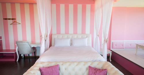 a bedroom with a bed with pink and white stripes at Whitecaps B&B in Yanliau
