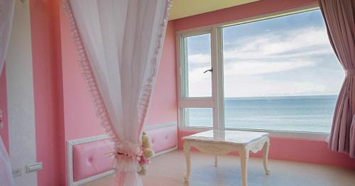 a room with a window and a table in front of the ocean at Whitecaps B&B in Yanliau