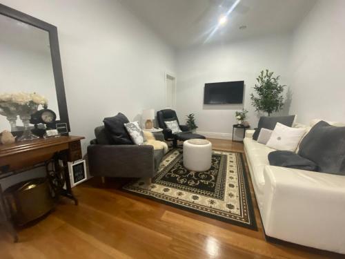 ein Wohnzimmer mit einem weißen Sofa und Stühlen in der Unterkunft Newport Cottage sleeps 5 in Newport