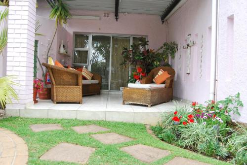 a patio with wicker furniture on a house at Ronique's Guest House in Rustenburg