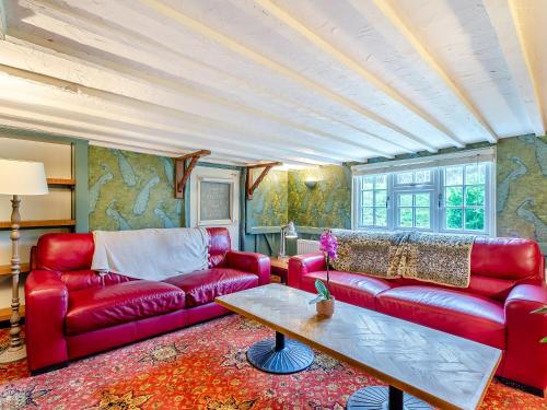 a living room with a red couch and a table at Hook & Hatchet - Uk48201 in Bicknor