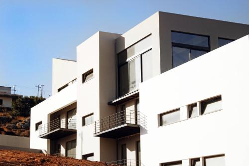 a white building with balconies on the side of it at Seametry Apartments in Souda