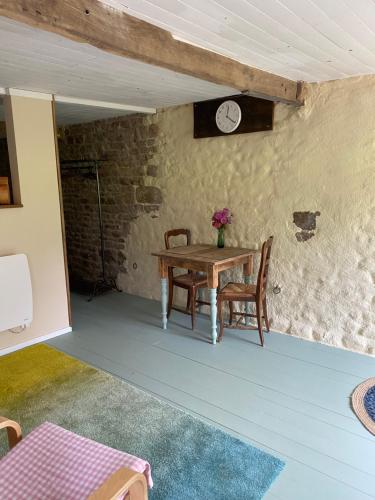 a room with a table and chairs and a clock at La Criberie in Saint-Ellier-du-Maine