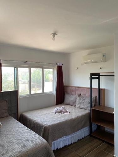 a bedroom with two beds and a window at Pousada Ap in Acaraú