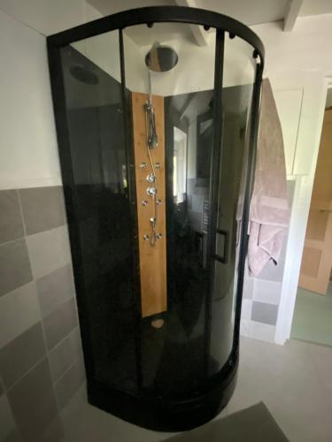 a large glass shower in a bathroom with a mirror at La Criberie in Saint-Ellier-du-Maine